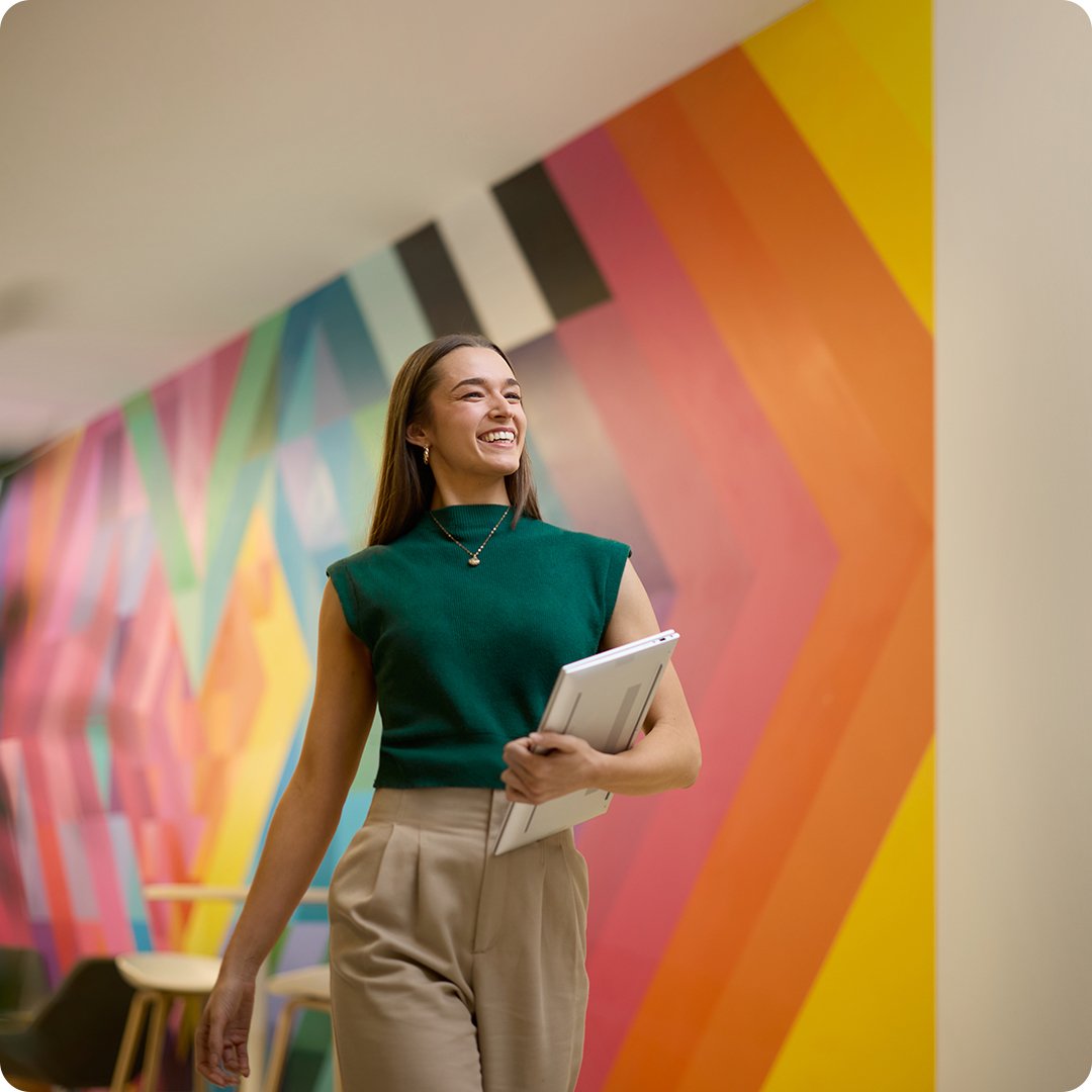 Diversity Equity Inclusion Woman in office in business attire wearing a green sleevless shirt with